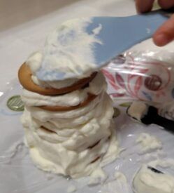 子どもと一緒ビスケットにクリームを塗って重ている様子